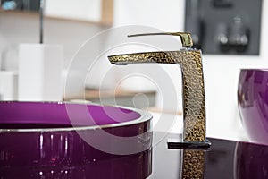 Bathroom detail in new luxury home: sink and golden faucet.