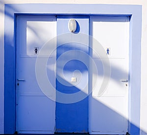 bathroom doors. white and light blue. man and woman