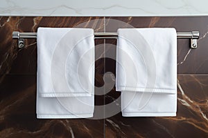 Bathroom elegance White towel hanging in a marble tiled wall bathroom