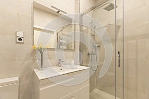 Bathroom with faux marble tiles, walk-in shower with sliding glass doors,