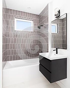 A bathroom with a floating cabinet and subway tile shower.