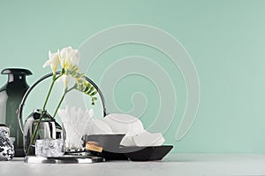 Bathroom interior with accessories for make up, skin cleansing - brush, mirror, cotton pads, vase, white flowers on white wood.