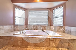 Bathroom interior with close up of bay windows and elevated built in bathtub