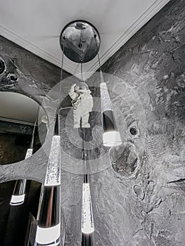 Bathroom interior with a cosmonaut lamp, round mirror, and gray wall texture