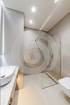 bathroom interior design with large mirror gray tiles and glass wall. higt res
