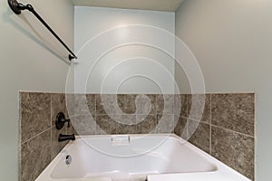 Bathroom interior with drop in tub with brown tile surround