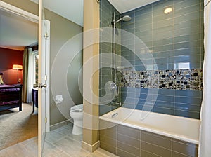 Bathroom interior with tile shower wall, and floor.
