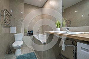 Bathroom interior with toilet and washbasin and big mirror on wall