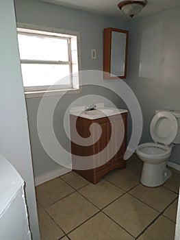 Bathroom with medicine cabinet a toilet and small sink with storage