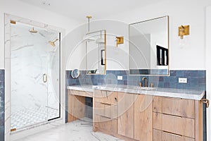 A bathroom with a natural wood cabinet and blue tiles.