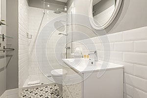 Bathroom with one piece sink, white framed round mirror