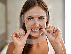 Bathroom, portrait and woman flossing teeth for dental health, care and hygiene for smile. House, female person and