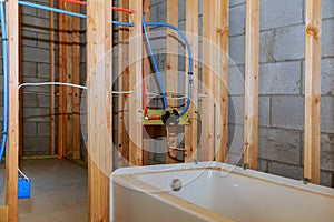 Bathroom remodel showing under floor plumbing work connecting installation of pipes for water for new buildings