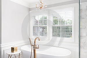 A bathroom`s standalone tub with a gold faucet.