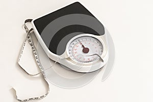 Bathroom scales and a tape measure showing inches