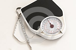 Bathroom scales and a tape measure showing inches