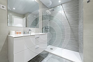 Bathroom with shower cabin with glass partition, white porcelain