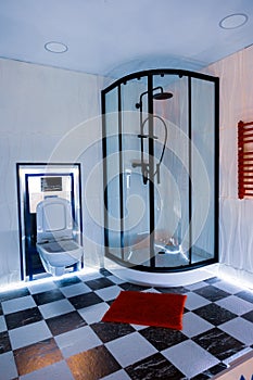 Bathroom with shower and toilet. Black and white check tiled floor