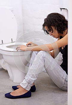 Bathroom, sick and woman on a floor suffering from anorexia, depression or anxiety. Stress, toilet and female with body
