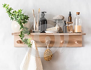 Bathroom simple interior - wooden shelf-hanger with accessories for care and beauty on a light background