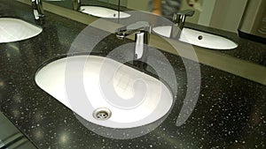 Bathroom sinks and touchless taps in public toilet and restroom. Modern faucet. Virus protection concept. Sanitary rules and requi