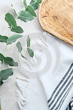 Bathroom stone table with eucalyptus branches, wooden board, towel. Cosmetic product placement concept photo