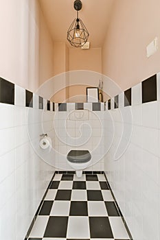 a bathroom with a toilet and black and white tiles