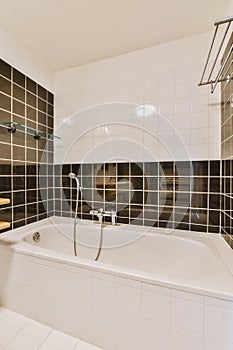 a bathroom with a tub and black and white tiles