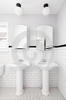 A bathroom with two pedestal sinks.