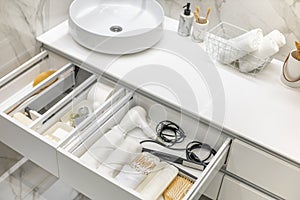 Bathroom under sink organizer drawers with neatly placed bath amenities and toiletries.