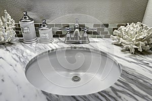 Bathroom vanity cabinet with white granite top. Sink and decorated corals