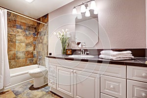 Bathroom with white cabinets and title floor