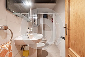 Bathroom with white furniture, square shower cabin, white toilets, white access door, stoneware floors