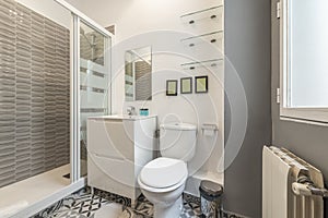 Bathroom with white resin sink, white wooden furniture, shower cabin