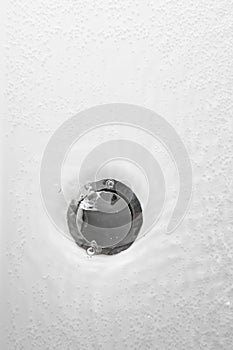 bathtub drain with water and bubbles