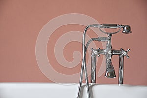 bathtub faucet on rim of old bathtub