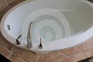 Bathtub Faucet With Water Running in the Bathroom