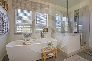 Bathtub and shower stall in front of windows with valance and blinds