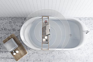 Bathtub with water tiled bathroom, book top view