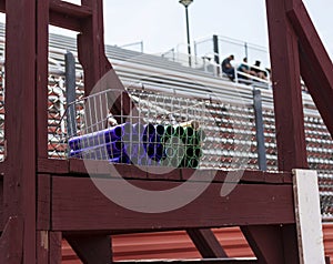 Batons in a medal basket with bleachers behind