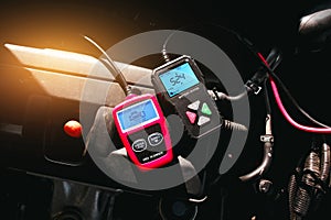 Battery tester and OBD or OBD2 scanner on engine compartment