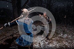 The battle between medieval knights in the style of Game of Thrones in winter forest landscapes. Spear against sword