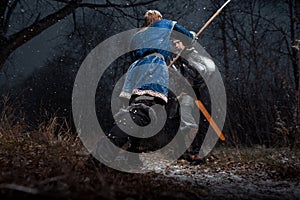 The battle between medieval knights in the style of Game of Thrones in winter forest landscapes. Spear against sword