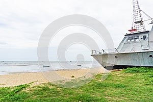 Battle metal ship on sand beach