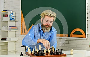 Battle of minds. bearded man training for chess competition. chess figures on wooden board. Focused school teacher