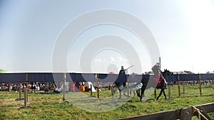 The battle of two strong men in medieval armor on horseback. Knights tournament.