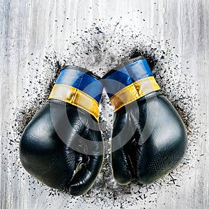 Battle-weary boxing gloves on wooden background