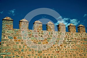 Battlement with merlons and crenels over stone wall at Avila