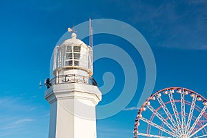 Batumi, Georgia - January 18, 2024: Batumi Lighthouse and Ferris wheel against the blue sky