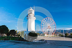 Batumi, Georgia - January 18, 2024: Batumi Lighthouse and Ferris wheel against the blue sky